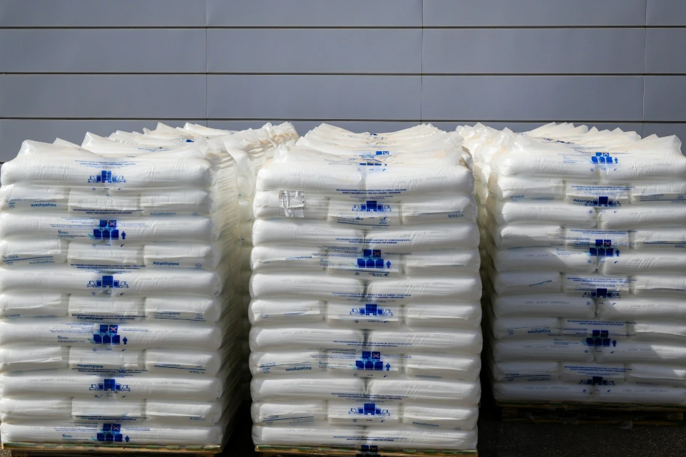 Three stacks of white sacks with blue labels
